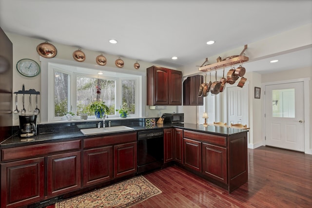 kitchen featuring black appliances, dark countertops, a sink, and reddish brown cabinets