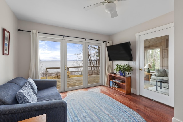 living area with wood finished floors, ceiling fan, and french doors