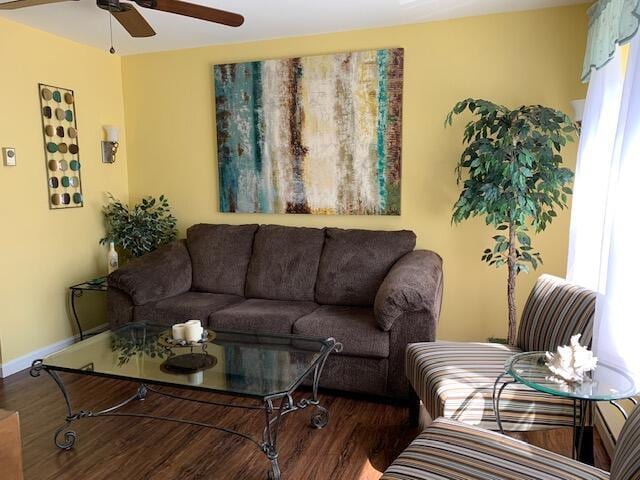 living area featuring wood finished floors, ceiling fan, and baseboards