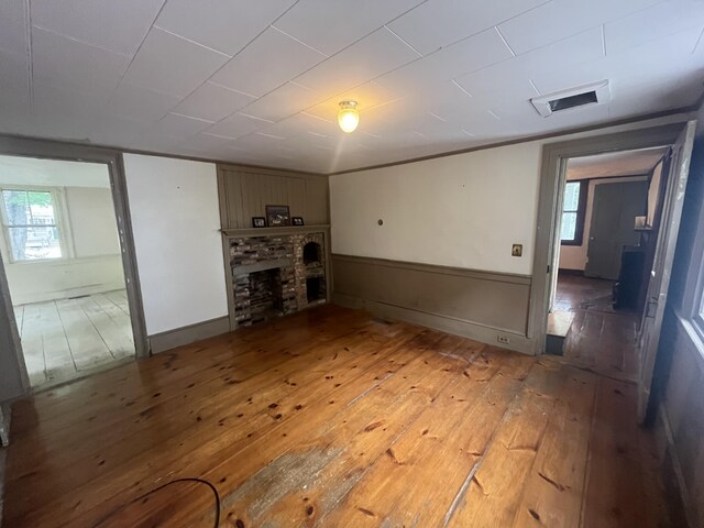 67 Elm St, Newfield, ME 04095 - unfurnished living room with wood-type flooring, a fireplace, and plenty of natural light