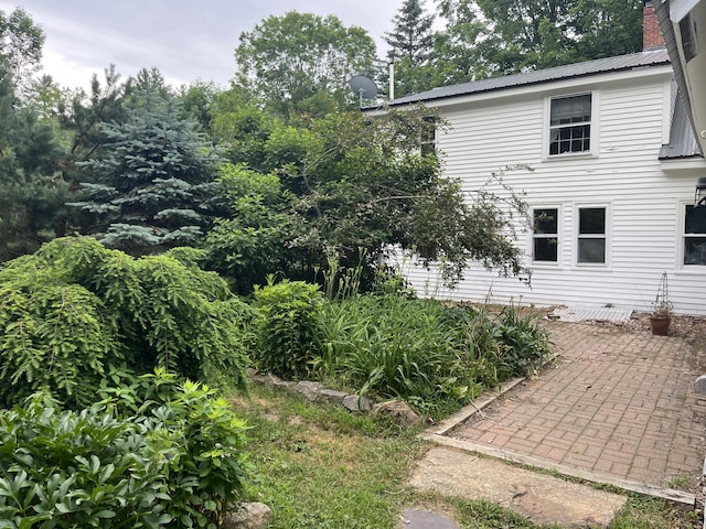 67 Elm St, Newfield, ME 04095 - view of side of home with a metal roof, a patio area, and a chimney