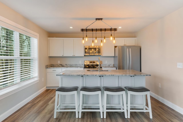 56 Old Kings Hwy, Ogunquit, ME 03907 - kitchen featuring dark wood-type flooring, a breakfast bar area, white cabinets, and stainless steel appliances