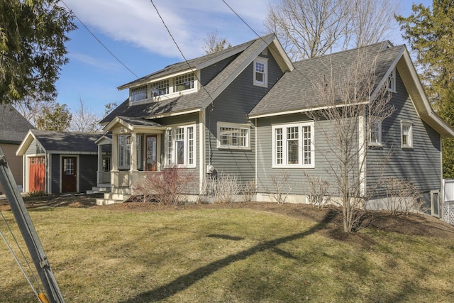 exterior space with a shingled roof and a front lawn