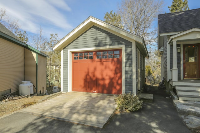 detached garage with driveway and central AC unit