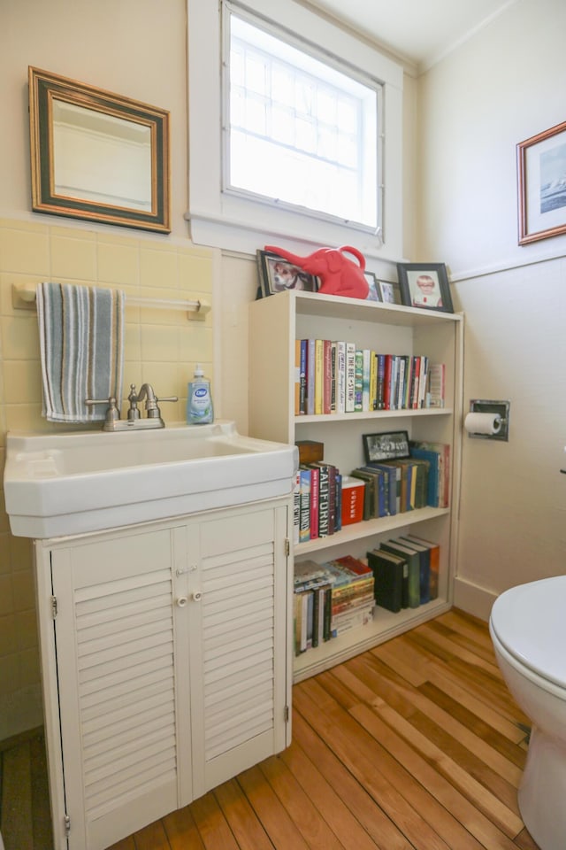 living area featuring light wood-style floors, tile walls, and crown molding