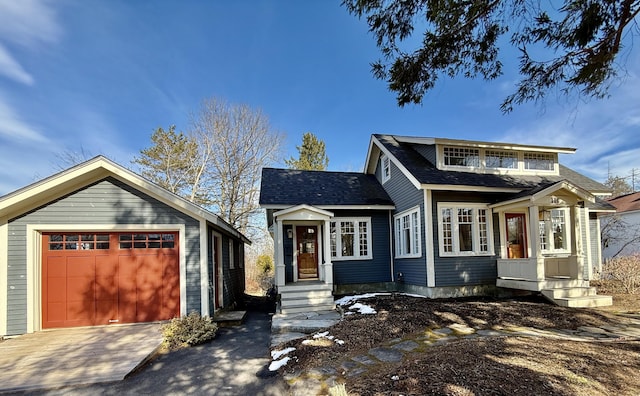 view of front facade featuring an outbuilding, a garage, driveway, and roof with shingles