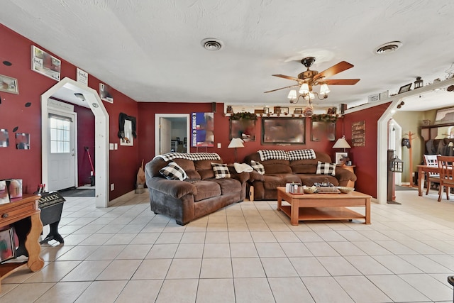living room featuring light tile patterned floors, visible vents, and ceiling fan