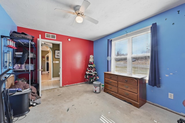 bedroom with visible vents, a ceiling fan, baseboards, concrete floors, and a textured ceiling