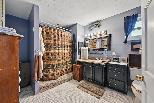 full bathroom with tile patterned floors, toilet, vanity, a shower with shower curtain, and a textured ceiling