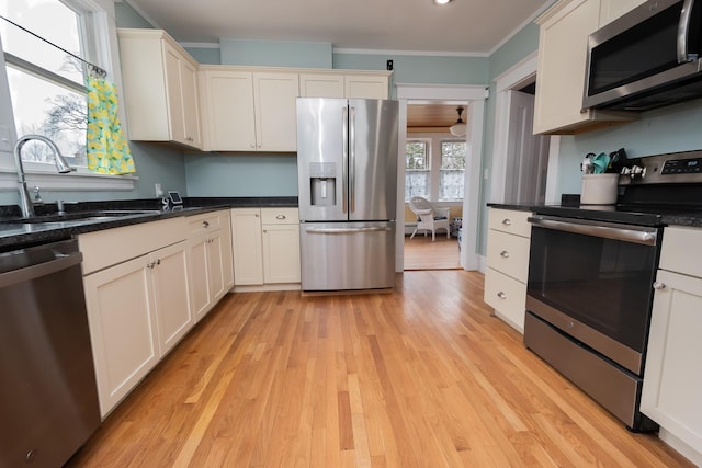 369 Ohio St, Bangor, ME 04401 - kitchen featuring stainless steel appliances, a sink, light wood-style floors, crown molding, and white cabinetry
