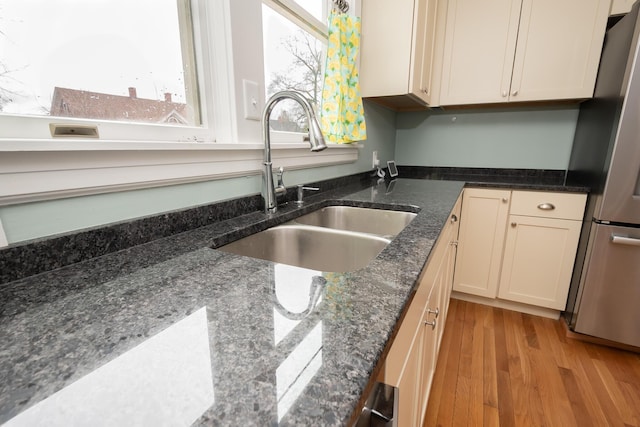 369 Ohio St, Bangor, ME 04401 - kitchen featuring a sink, freestanding refrigerator, light wood finished floors, and dark stone counters
