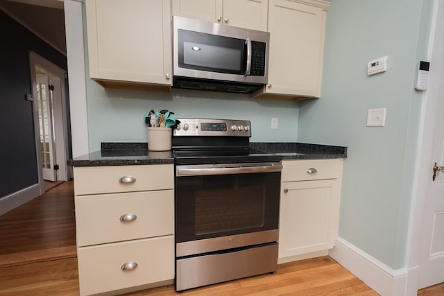 369 Ohio St, Bangor, ME 04401 - kitchen with appliances with stainless steel finishes, light wood-type flooring, baseboards, and dark stone countertops