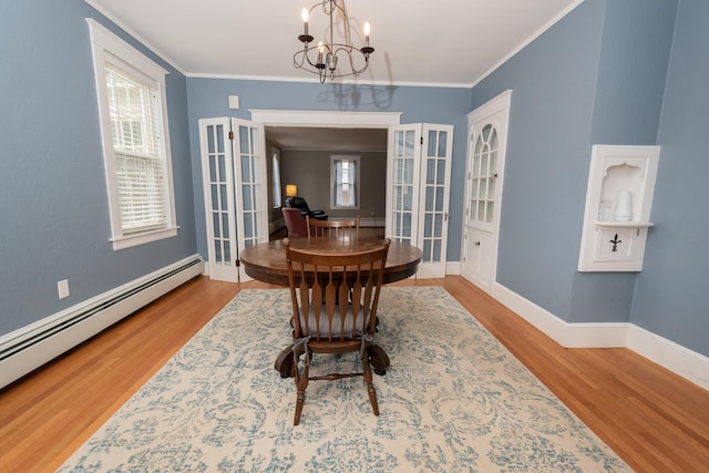369 Ohio St, Bangor, ME 04401 - dining space featuring a baseboard heating unit, a chandelier, wood finished floors, crown molding, and baseboards