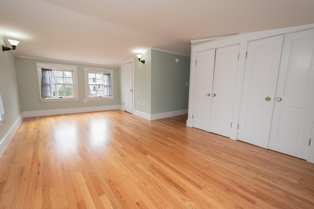 369 Ohio St, Bangor, ME 04401 - unfurnished bedroom with two closets, ornamental molding, light wood finished floors, and baseboards