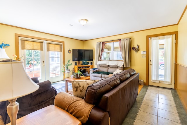 living room with light tile patterned floors, french doors, ornamental molding, and a healthy amount of sunlight