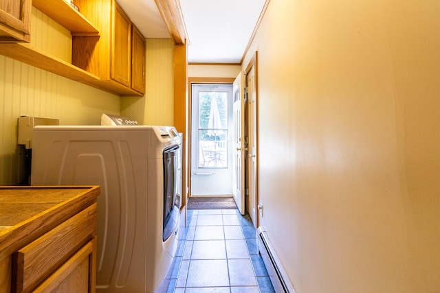 laundry room featuring separate washer and dryer, baseboards, baseboard heating, light tile patterned floors, and cabinet space