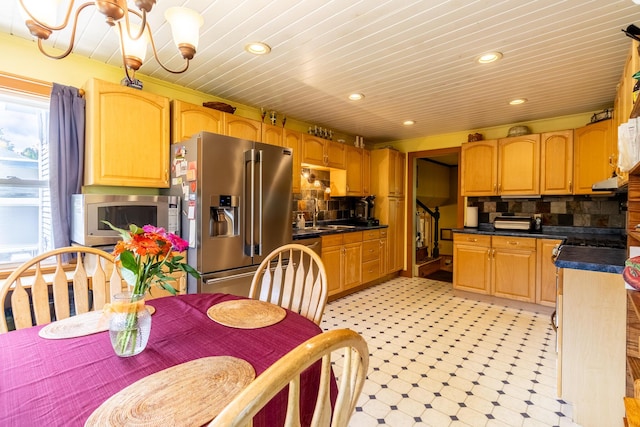 kitchen with dark countertops, recessed lighting, stainless steel appliances, decorative backsplash, and light floors