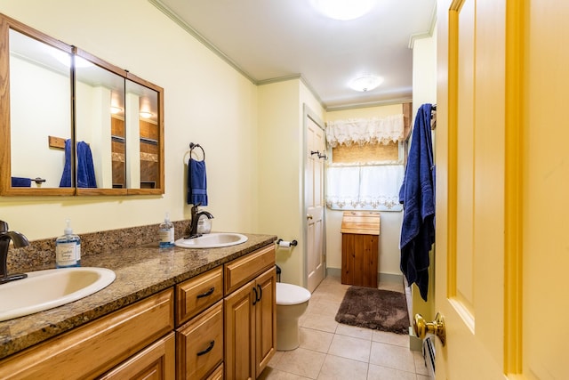 bathroom featuring ornamental molding, double vanity, a sink, and tile patterned flooring