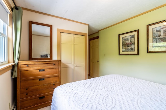 bedroom featuring ornamental molding, a baseboard radiator, and a closet