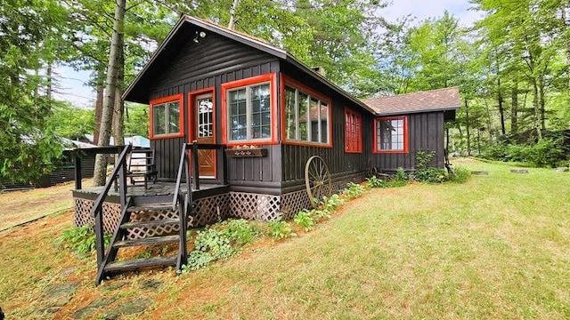 exterior space with a lawn, a deck, and board and batten siding