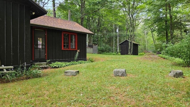 view of yard featuring an outdoor structure, entry steps, and a shed
