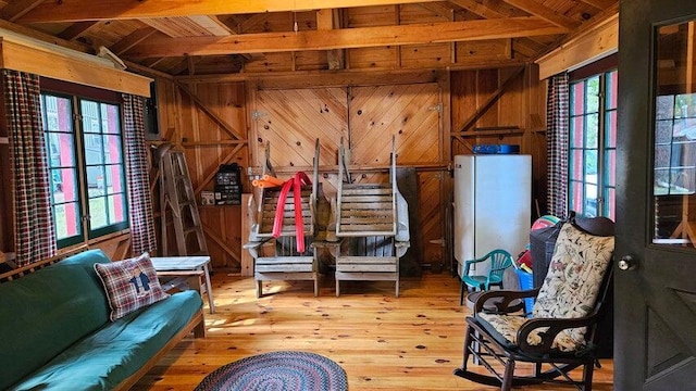living area with hardwood / wood-style floors, plenty of natural light, wooden ceiling, and wood walls
