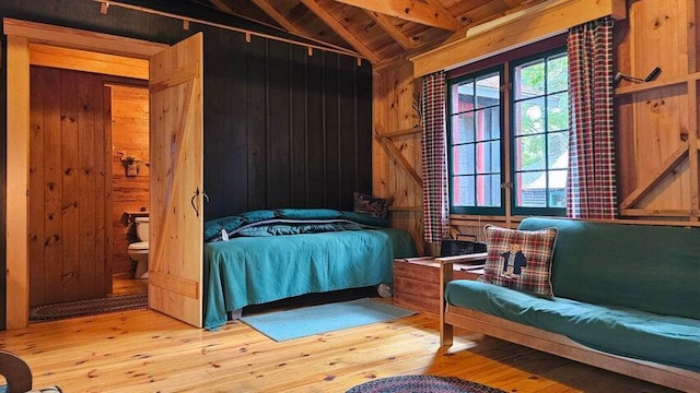 bedroom featuring lofted ceiling with beams, wooden walls, wooden ceiling, and hardwood / wood-style flooring