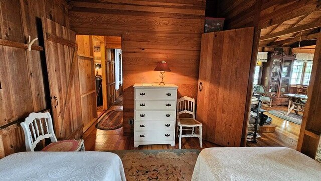 bedroom featuring wooden walls and wood finished floors