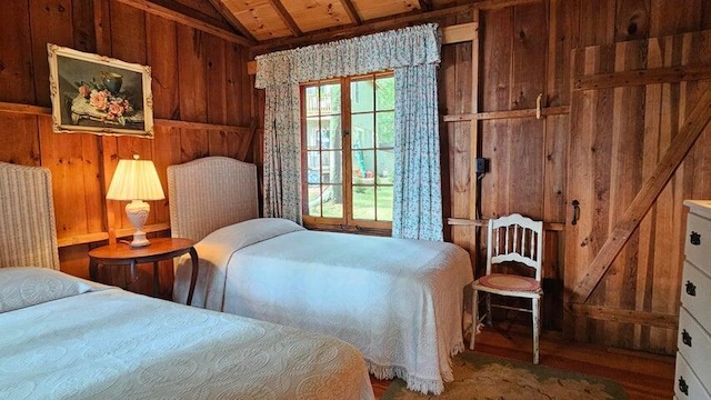 bedroom with lofted ceiling, wooden walls, wood finished floors, and wood ceiling