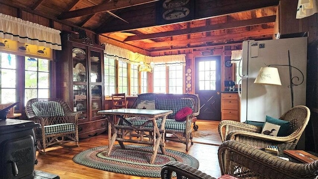 sunroom featuring beamed ceiling and a healthy amount of sunlight