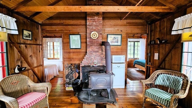 living area featuring wooden ceiling, a healthy amount of sunlight, vaulted ceiling with beams, and wooden walls