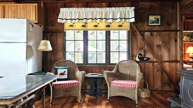 sitting room with wood finished floors and wood walls