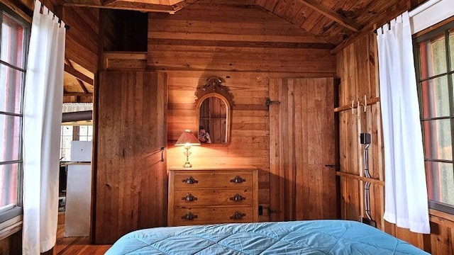 bedroom with wood ceiling, wood walls, and multiple windows