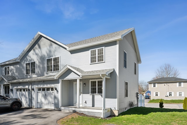 189 Saco Ave Unit 3, Old Orchard Beach, ME 04064 - view of front facade with a porch, asphalt driveway, a front lawn, a garage, and a shingled roof