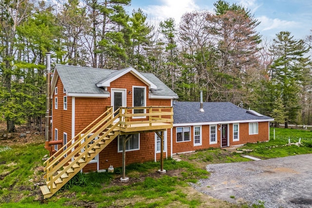 285 Hockomock Rd, Woolwich, ME 04579 - view of front of house featuring roof with shingles, a deck, stairway, and view of wooded area