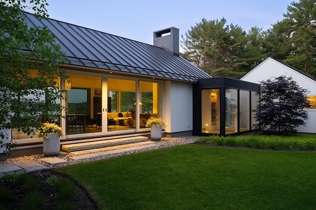 4 Ice House Pt, York, ME 03909 - back of property featuring a standing seam roof, metal roof, a chimney, a lawn, and a sunroom