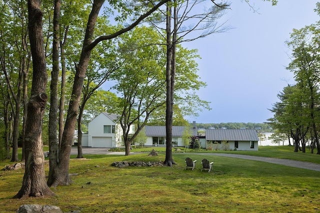 4 Ice House Pt, York, ME 03909 - view of front of house featuring an attached garage, a front lawn, driveway, and metal roof