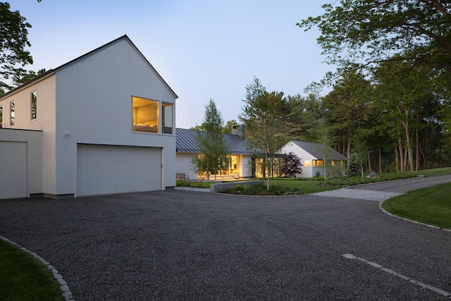 4 Ice House Pt, York, ME 03909 - modern home with a chimney, metal roof, a garage, and a standing seam roof