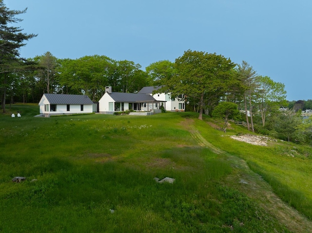 4 Ice House Pt, York, ME 03909 - view of front of house with metal roof, a front yard, and view of scattered trees