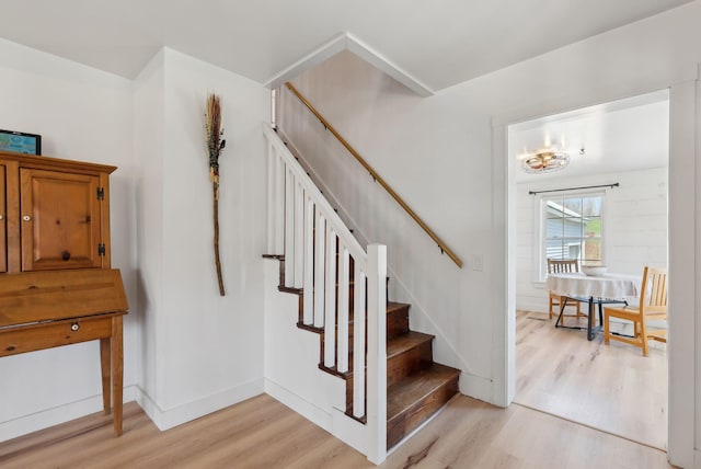 staircase featuring baseboards and wood finished floors