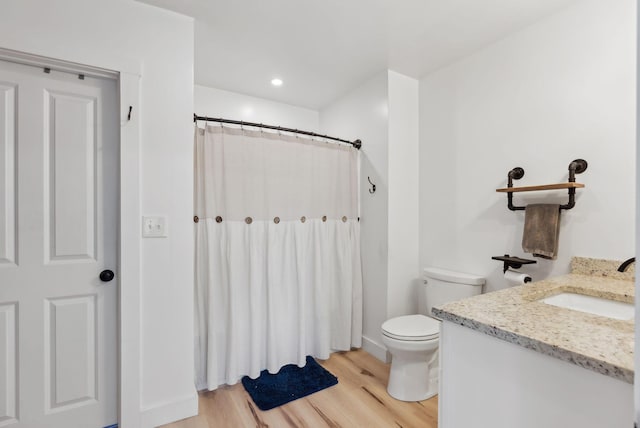 full bathroom with toilet, curtained shower, wood finished floors, and vanity
