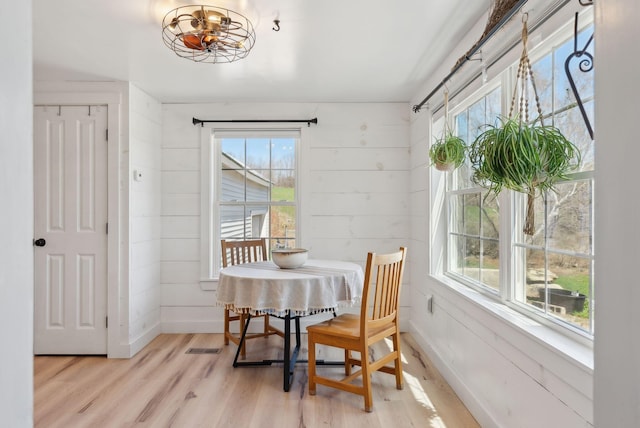 dining room with baseboards, light wood finished floors, and a chandelier