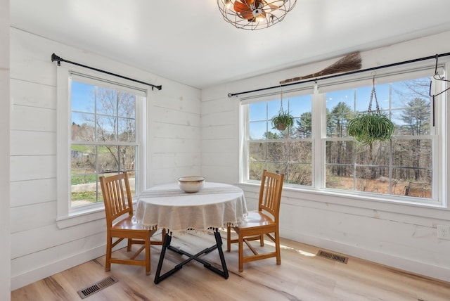 dining room featuring baseboards, light wood finished floors, and visible vents