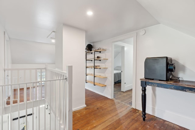 hall featuring recessed lighting, vaulted ceiling, hardwood / wood-style flooring, and an upstairs landing