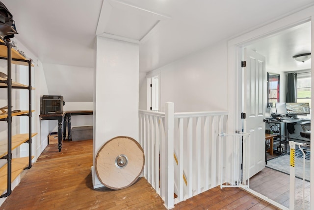 corridor featuring an upstairs landing and hardwood / wood-style flooring