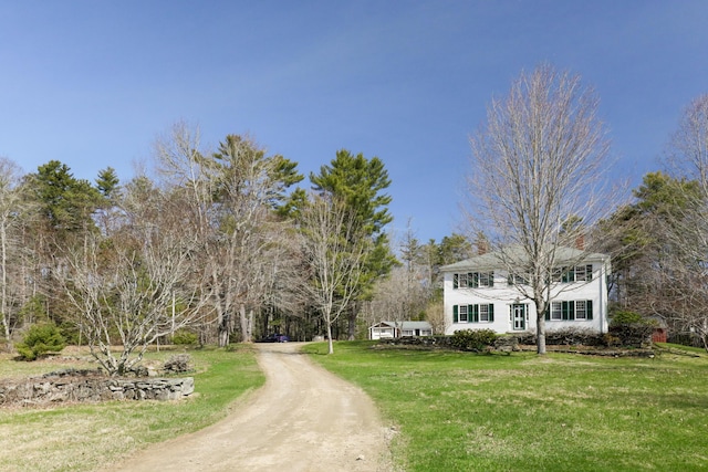 view of property's community with a yard and dirt driveway