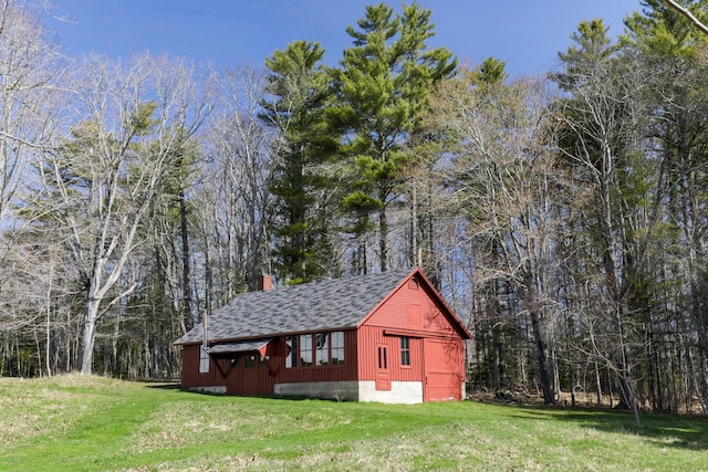 view of outbuilding with a view of trees and an outbuilding