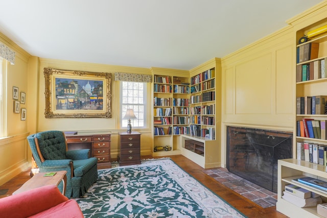 living area featuring a fireplace with flush hearth and dark wood-style flooring