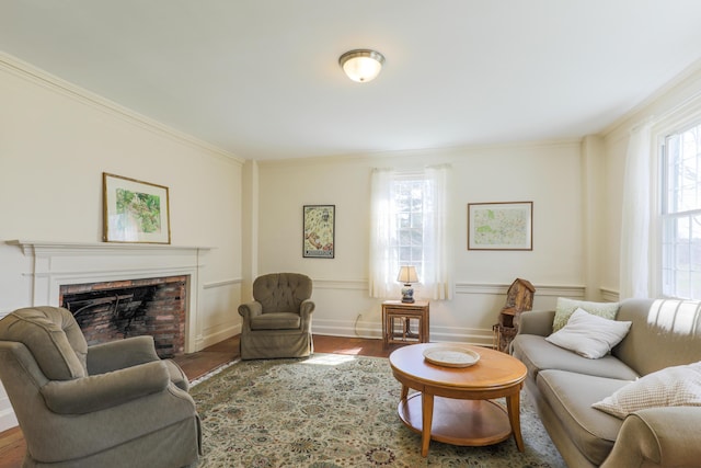 living room with baseboards, a brick fireplace, wood finished floors, and ornamental molding