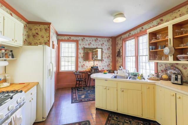 kitchen with open shelves, wallpapered walls, and cream cabinets